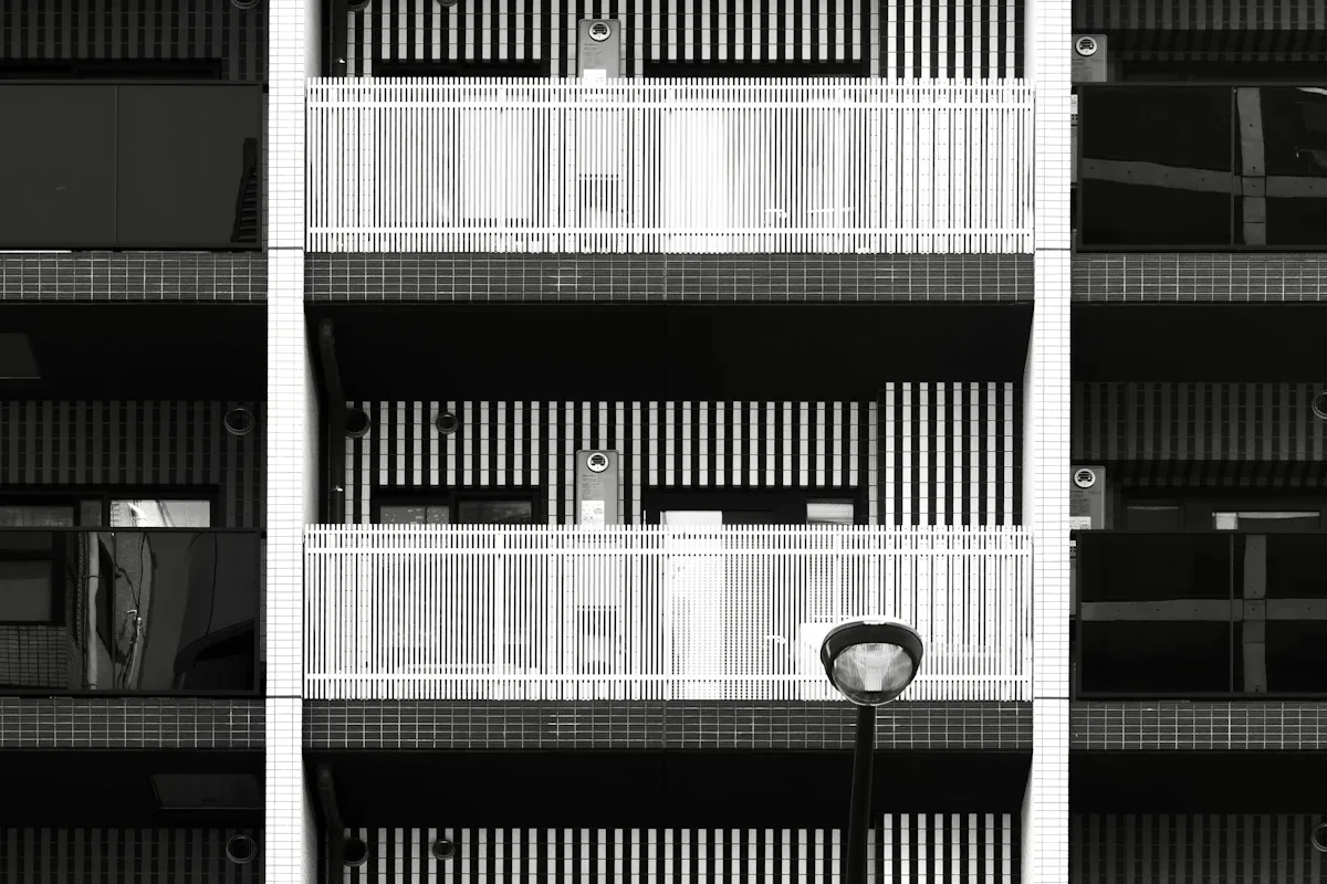 Fachada de edifício residencial com varandas e poste de iluminação em primeiro plano