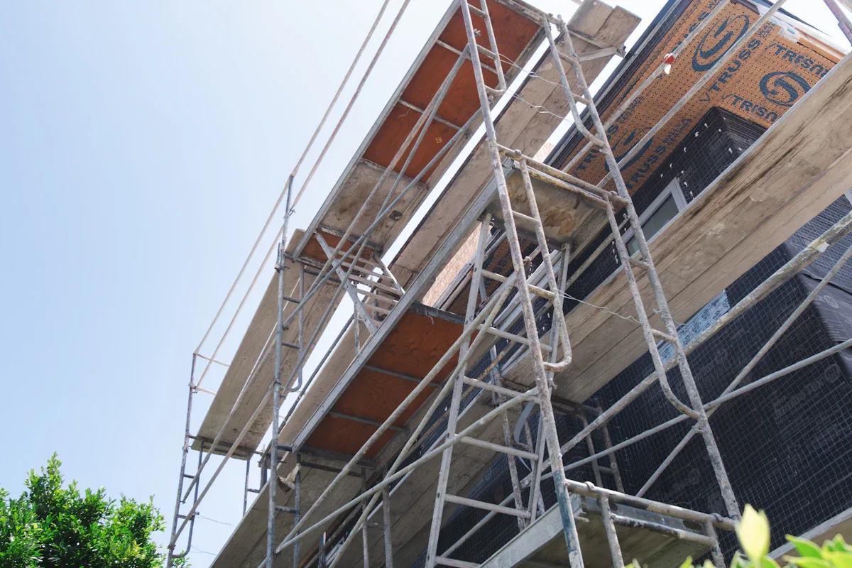 Edifício com andaimes montados junto à fachada sob céu claro