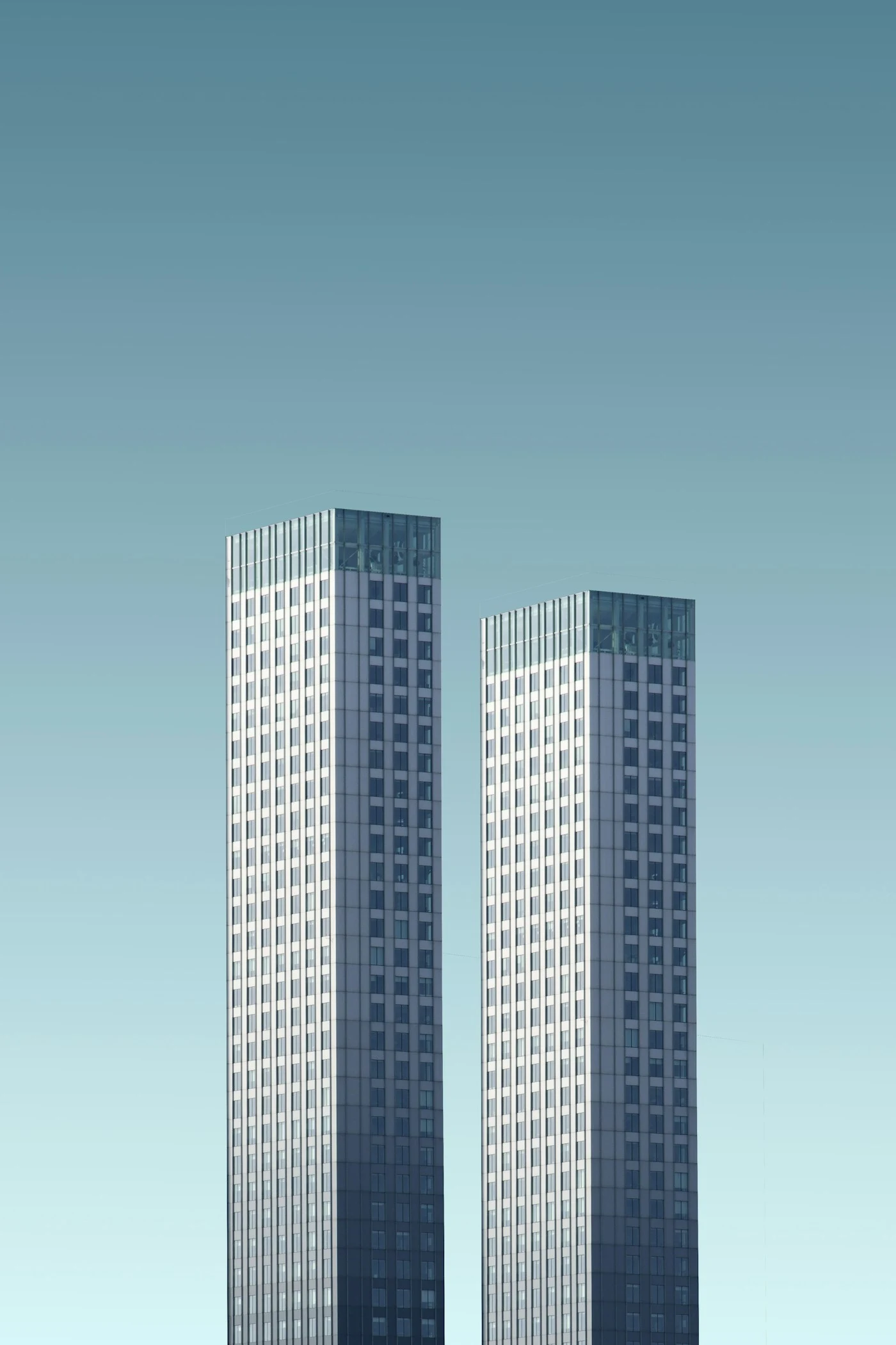 Duas torres modernas vistas de baixo sob céu azul