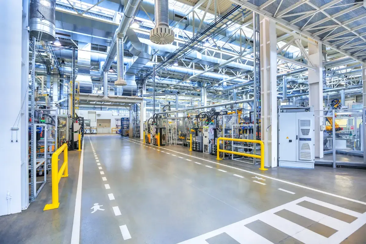 Área industrial com tubulações, equipamentos e piso sinalizado