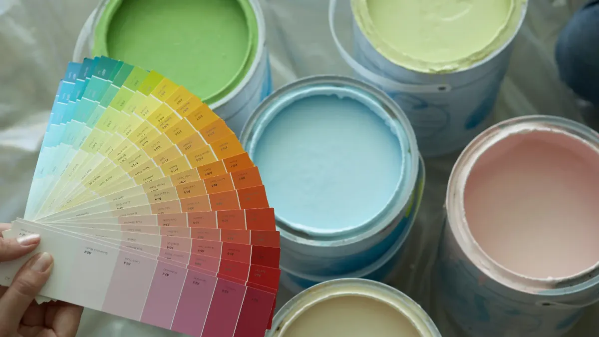 Leque de cores ao lado de latas de tinta abertas