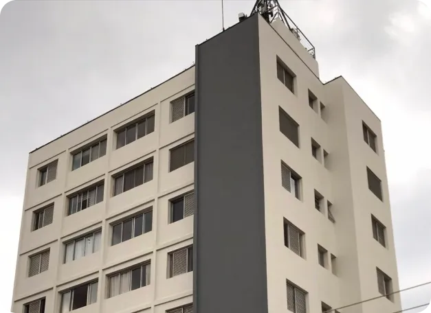 Edifício claro com janelas retangulares e cobertura plana